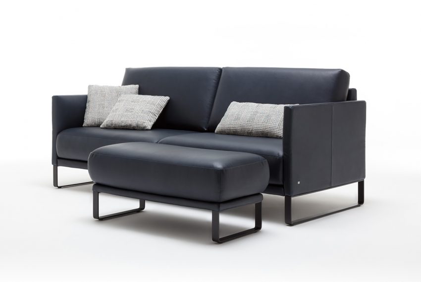 Ein schwarzes Rolf Benz Cara Sofa mit dazugehörigem Loungehocker