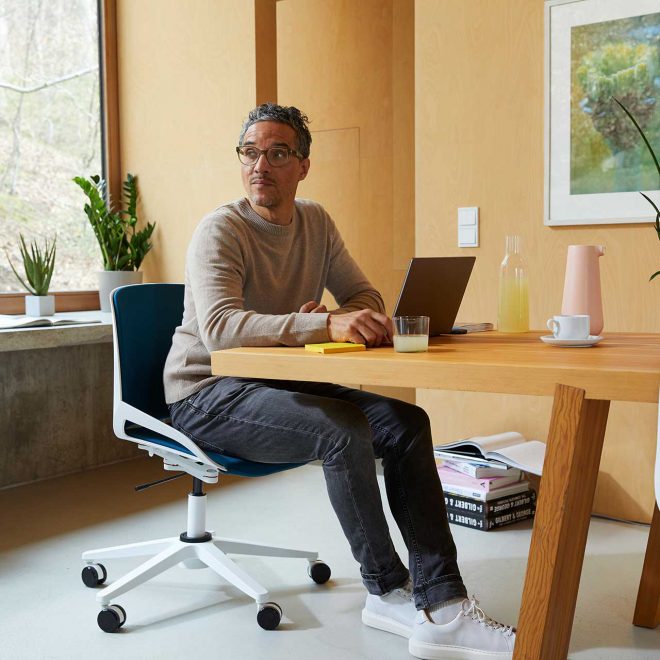 Ein Mann im Home-Office sitzt auf einem aeris Numo Task.